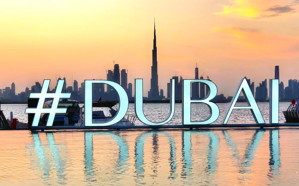 Sunset over the Creek Island promenade with Burj Khalifa across the water at Dubai Creek Harbour