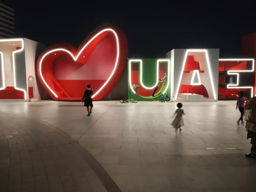 Families at an illuminated evening plaza in Dubai Creek Harbour